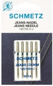 Schmetz and Organ sewing machine needle packages on a wooden workbench